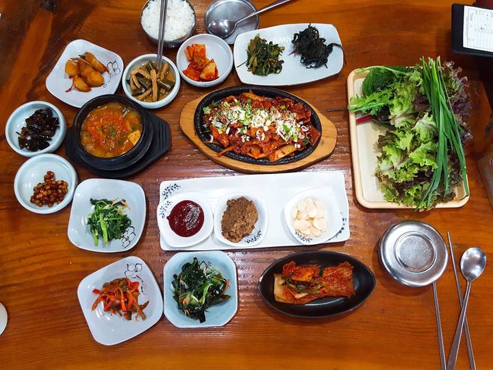 제육볶음과 찌개, 반찬, 쌈 채소가 차려진 쌈밥 한 상